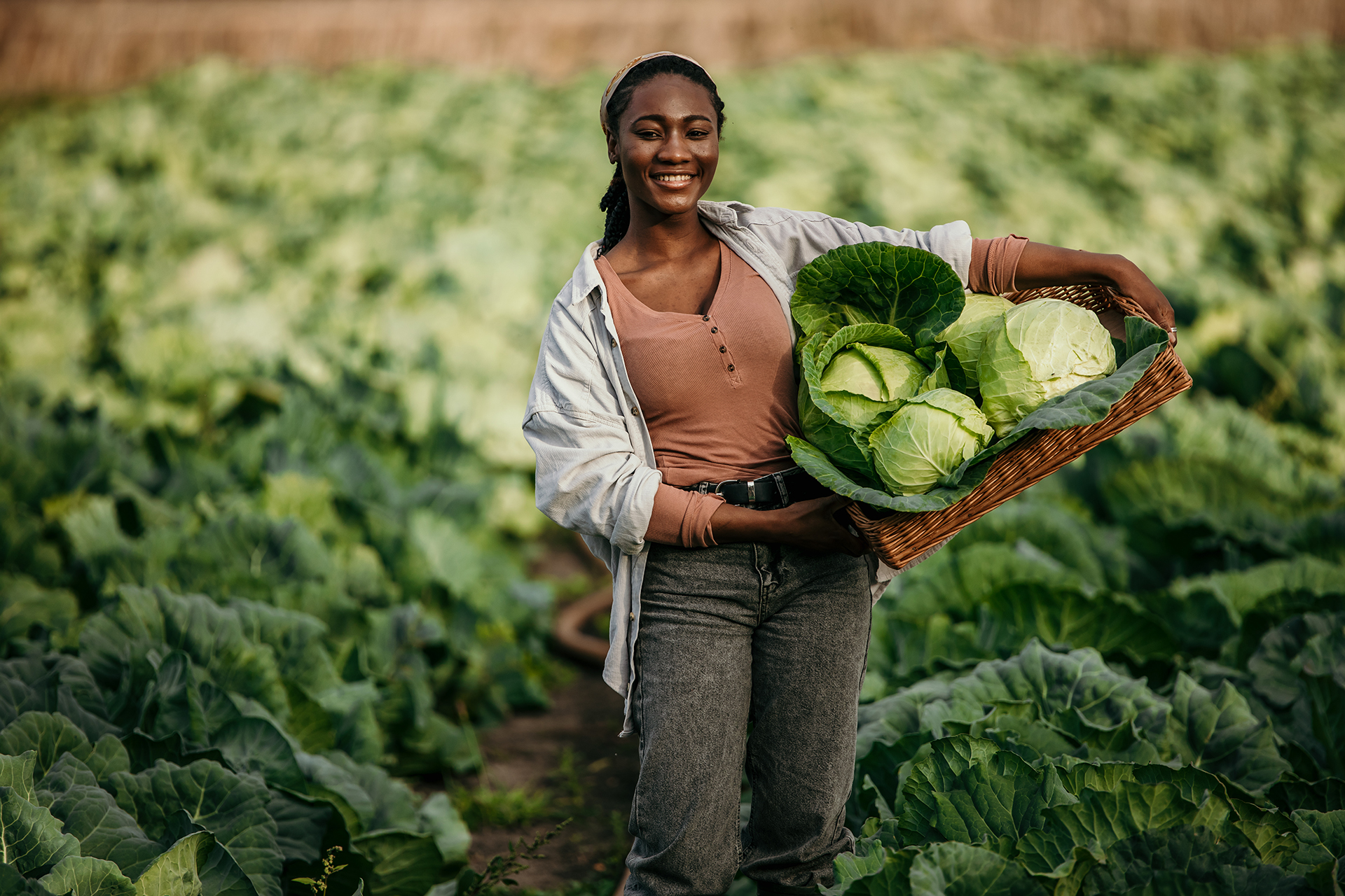 Shot of an attractive young female farmer carrying a crate of vegies